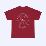 The Thank God I'm Gay Shirt is a maroon LGBTQ tee with a white line illustration of a teddy bear, hearts, and stars, plus the text "Thank God I'm Gay" above and below the bear.