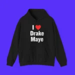 The I Love Drake Maye Shirt is a black tee with "I ♥ Drake Maye" printed in white and red on the front, shown against a bright blue background.