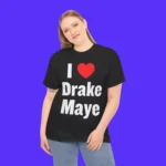 A woman smiles against a solid purple background, wearing the I Love Drake Maye Shirt featuring “I ♥ Drake Maye” in bold white and red letters.