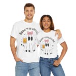 A smiling couple with arms around each other wear matching Boo-Racha Shirts, which feature a cartoon ghost with a pink bow holding a beer mug and the text “Booo-rrrraaccha.”.
