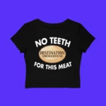 The No Teeth Destination Smokehouse For This Meat Shirt is a black crop top with bold white "NO TEETH FOR THIS MEAT" text and an oval Destination Smokehouse logo, shown on a solid purple background.