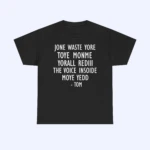 Black t-shirt with white text in an all-caps font that reads: JONE WASTE YORE TOYE MONME YORALL REDIII THE VOICE INSODE MOYE YEDD - TOM. The shirt is displayed on a plain light background.